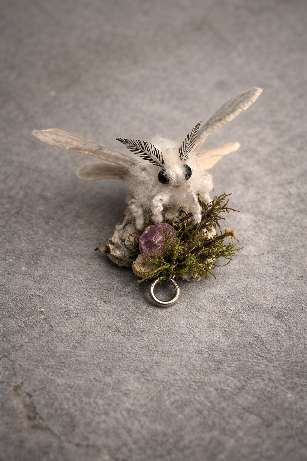 Handmade moth sculpture with botanical jewellery — moss, flowers, and stones